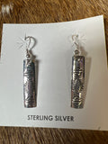 Silver earrings by Felicia Etcitty
